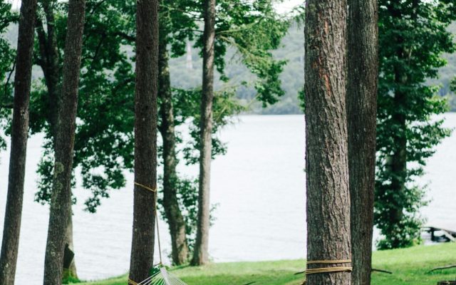Hängematte zwischen Bäumen am See, Symbolbild Erholung und Entspannung