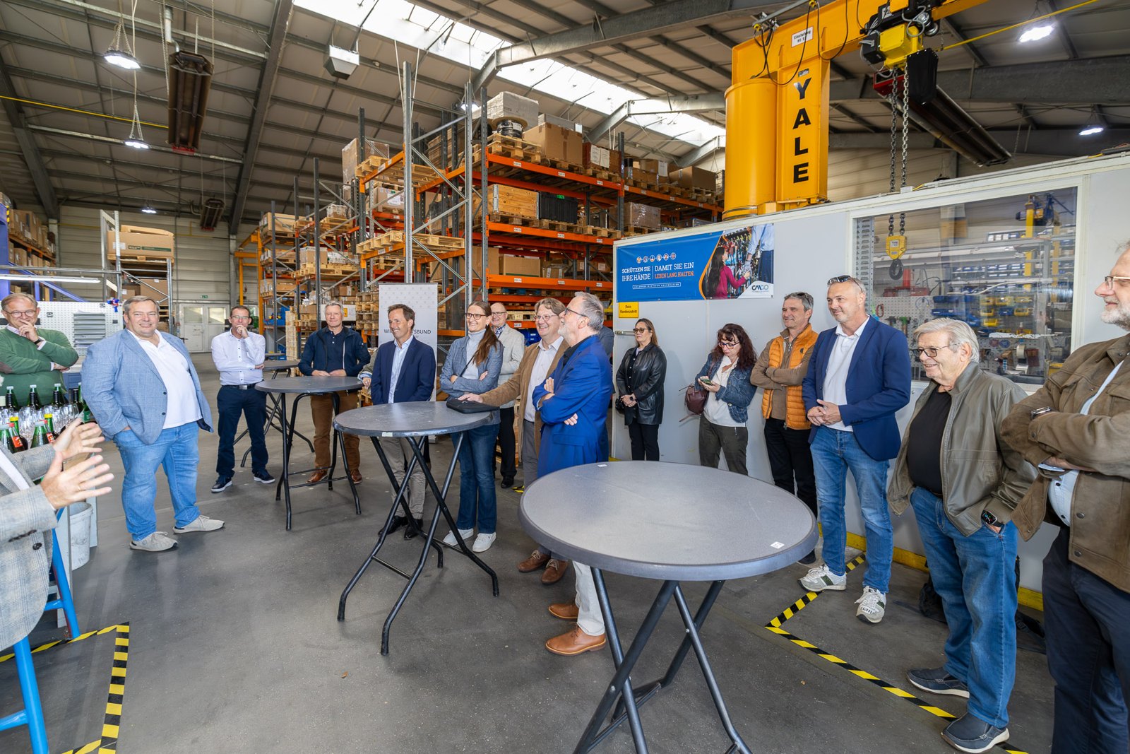 Gäste des UnternehmerInnen-Datings hören in der Lagerhalle von Columbus McKinnon einem Vortrag zu