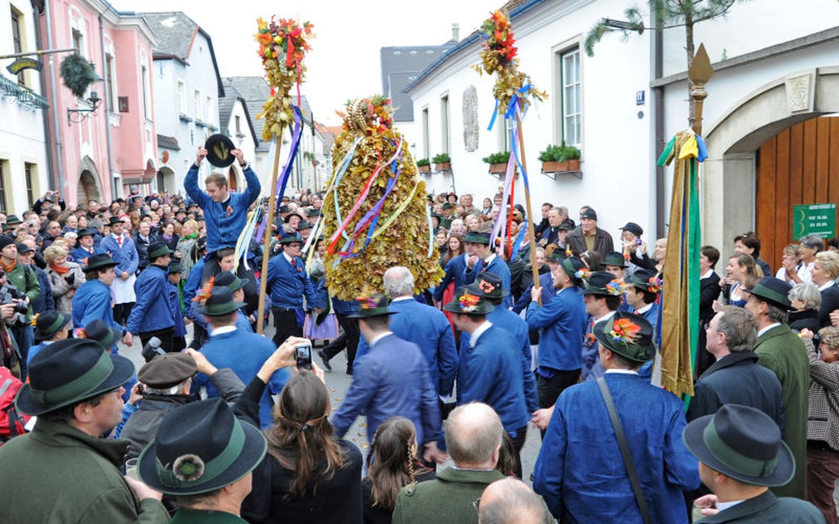Die Pritschn, die Erntekrone, wird beim Hiataeinzug in Perchtoldsdorf von Hiata in blauer Tracht durch die Menge getragen